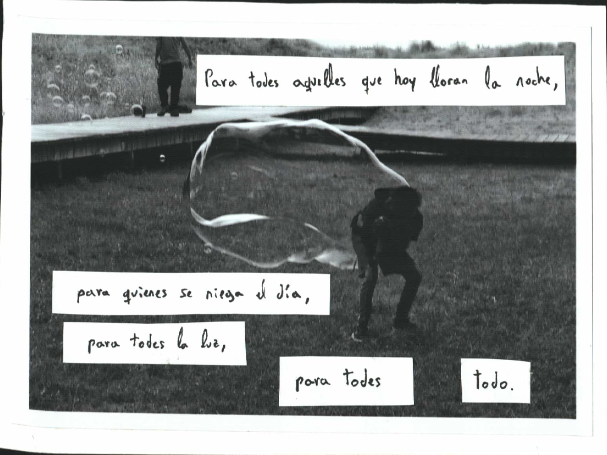 Padre jugando con hijo bajo una pompa de jabón enorme. Texto del manifiesto zapatista.