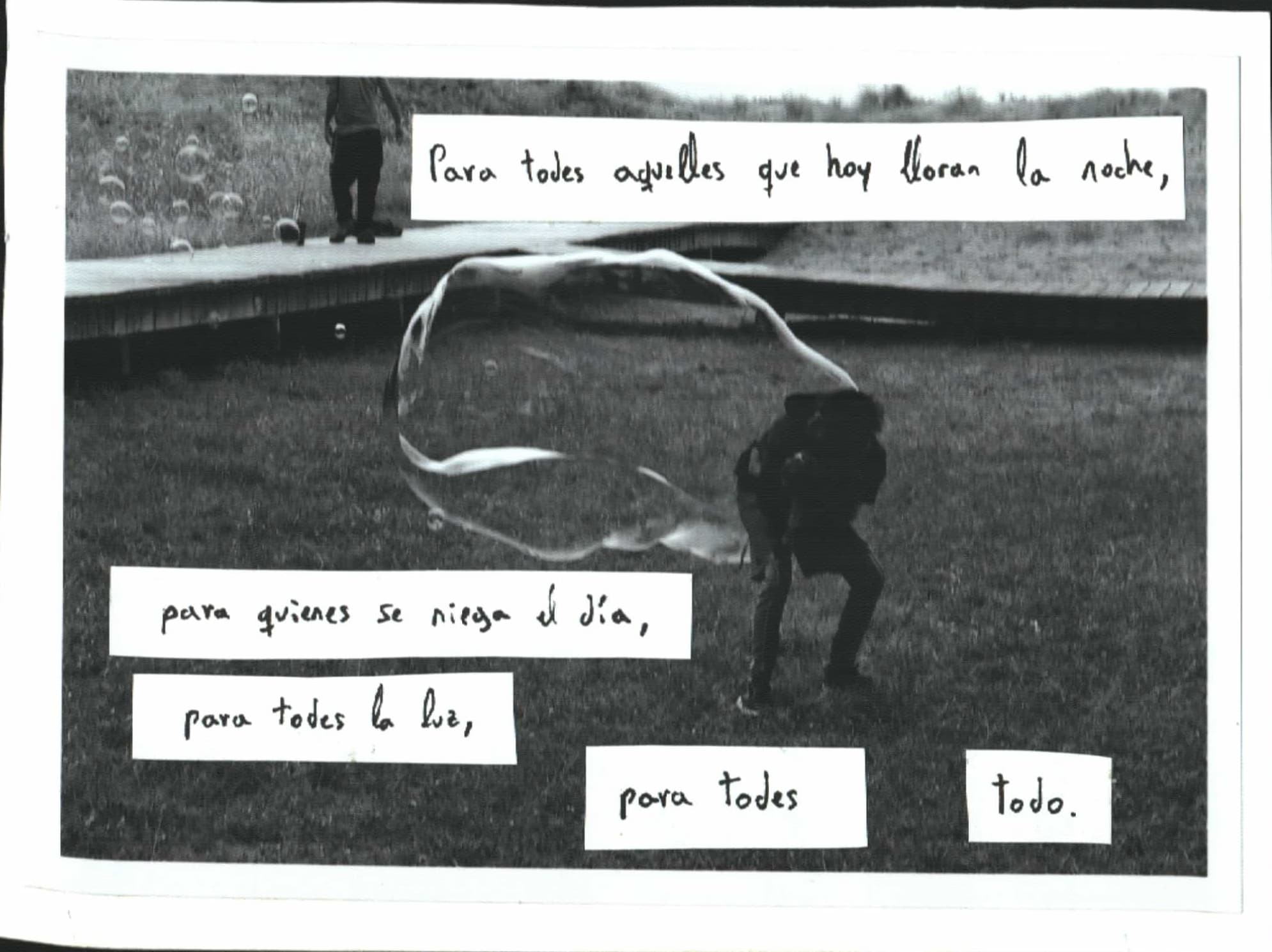 Padre jugando con hijo bajo una pompa de jabón enorme. Texto del manifiesto zapatista.